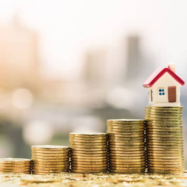 Stack of coins with model house at the top